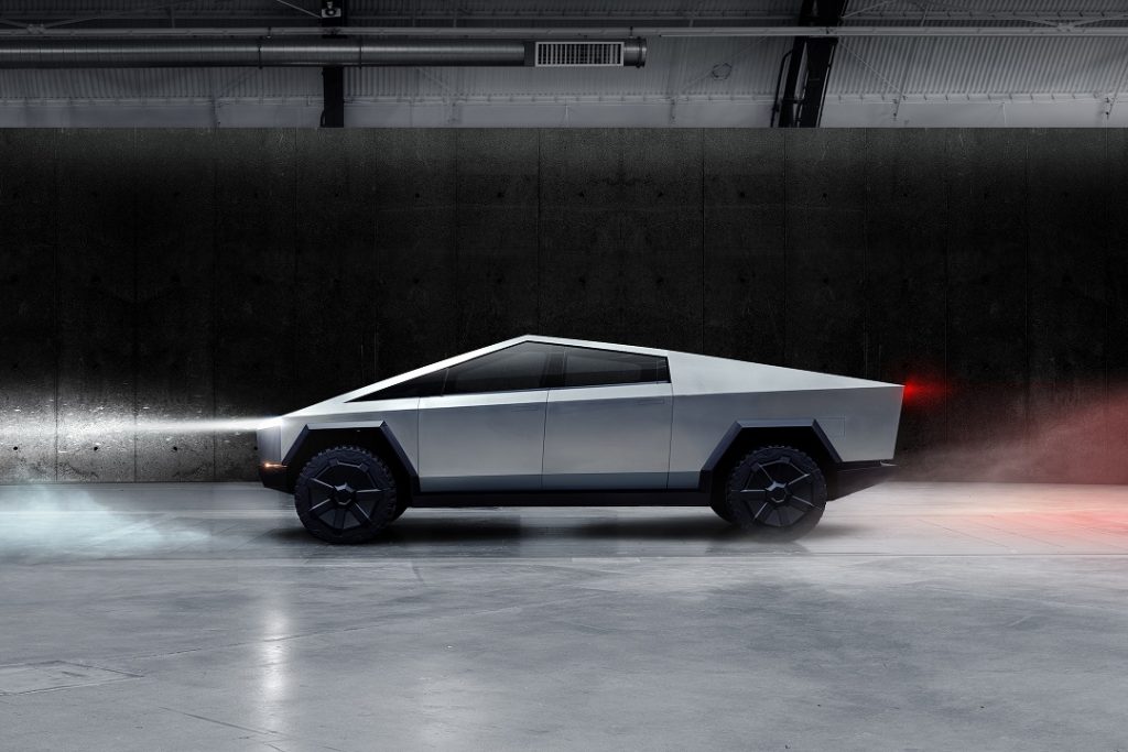 Tesla: Inovação, design, tecnologia e beleza, beleza? 2 vist lateral do carro com as luzes acesas.