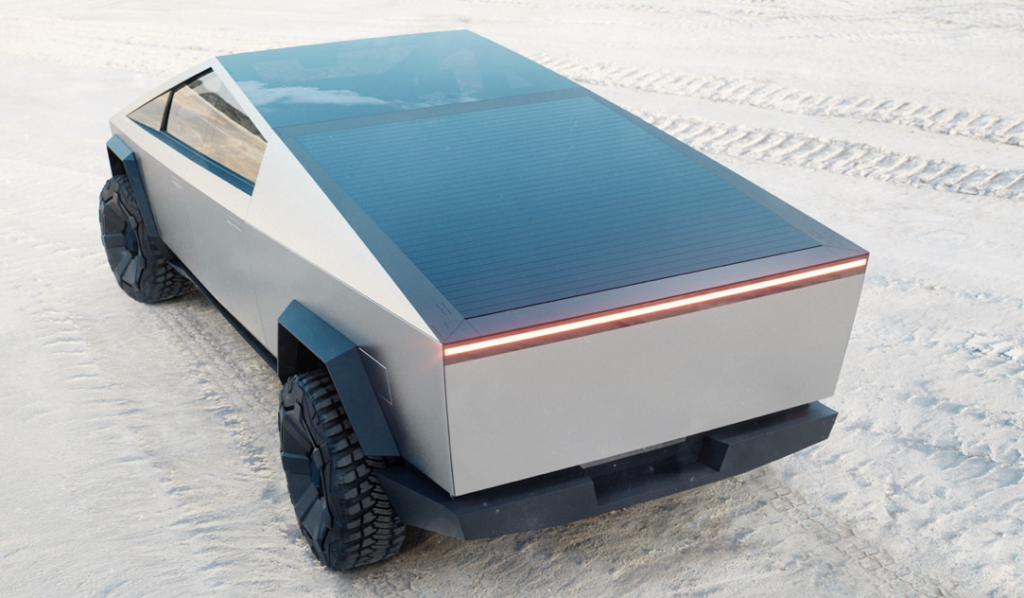 Tesla: Inovação, design, tecnologia e beleza, beleza? 3 vista superior do carro que está na areia onde podemos ver marcas de pneu no chão e o carro prateado com o teto em vidro preto estacionado.
